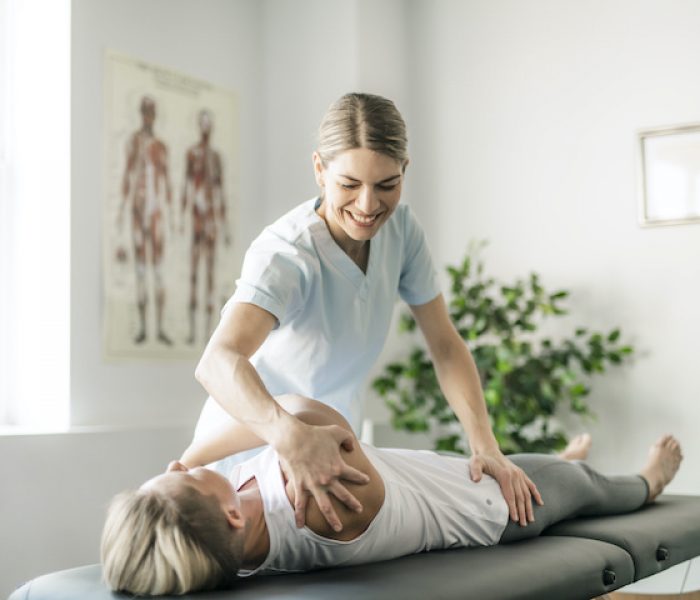 Modern rehabilitation physiotherapy worker with woman client