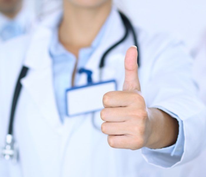 Group of doctors showing OK or approval sign with thumb up. High level and quality medical service, best treatment and patient care concept.